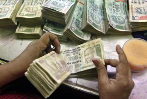 An employee counts Indian currency notes at a cash counter inside a bank in Kolkata