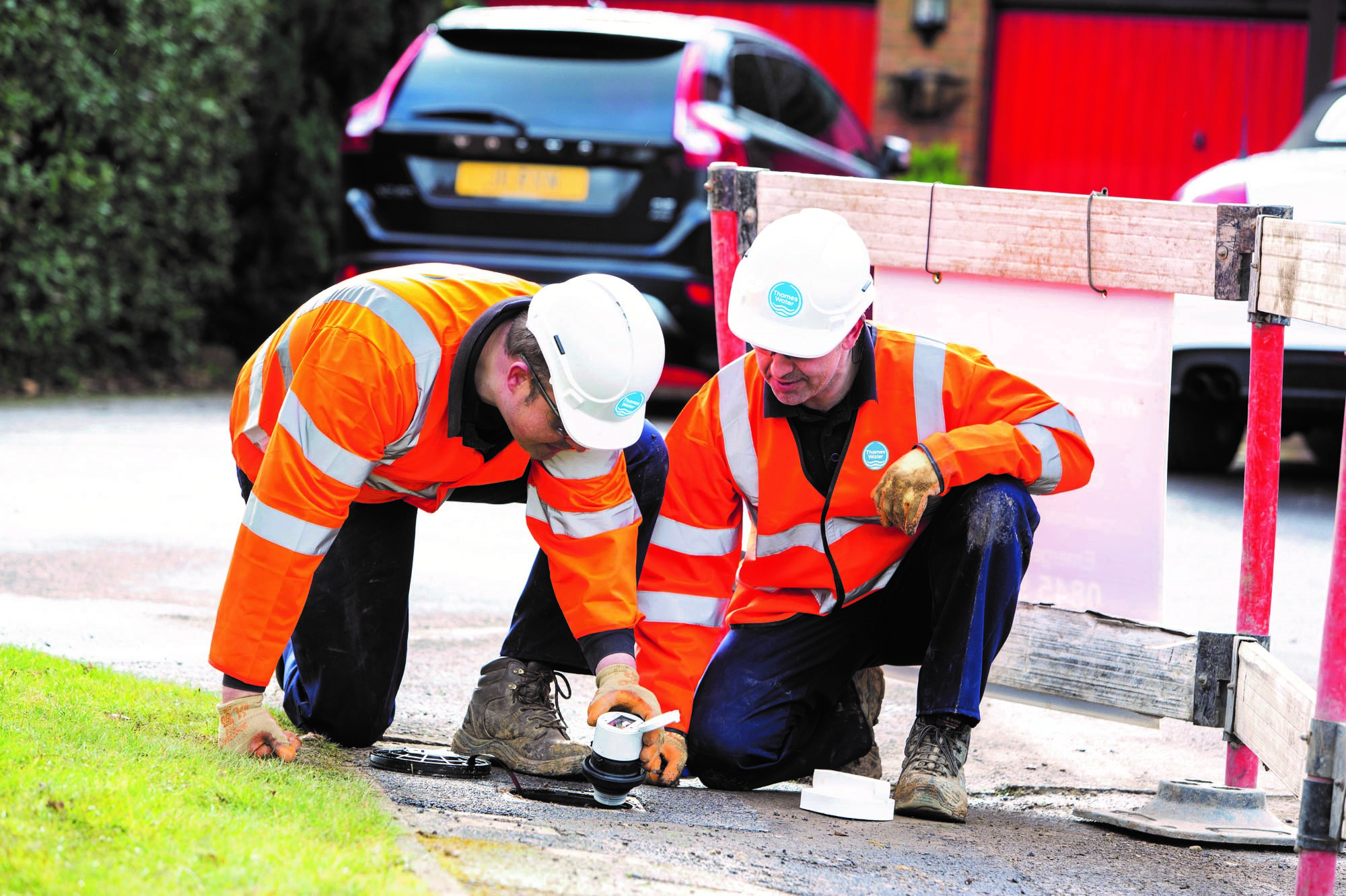 2 men in high vis jackets inspecting a smart meter